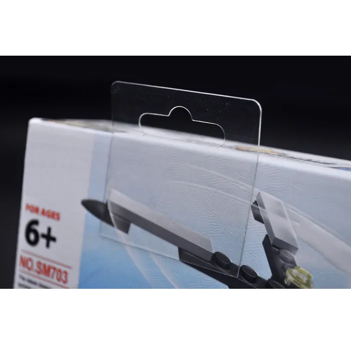 Close-up view of a transparent hang tab applied to a toy box, highlighting its see-through design and attachment method.