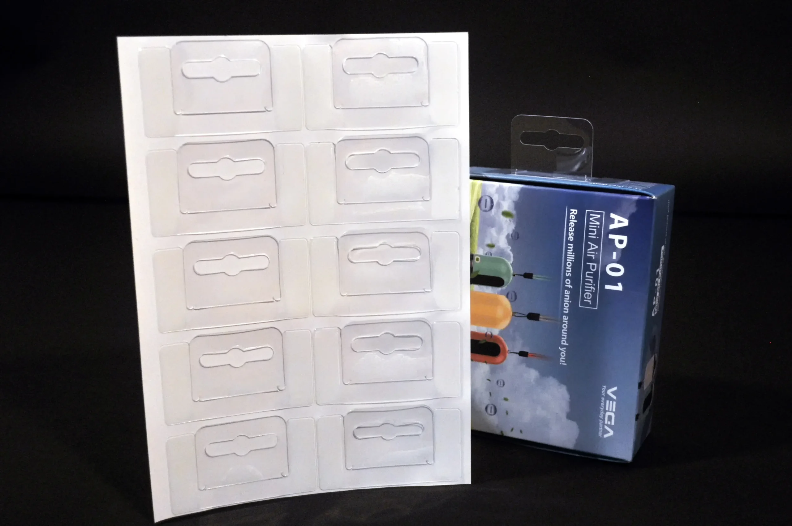 Clear PET adhesive hang tabs on sheet with Euro hole, shown with retail packaging for hanging display application.