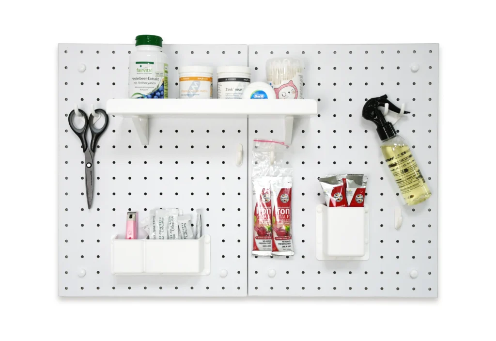 Modular pegboard wall organizer with hooks, shelves, and bins for home organization, holding nail clippers, cotton swabs, supplements, and daily essentials.
